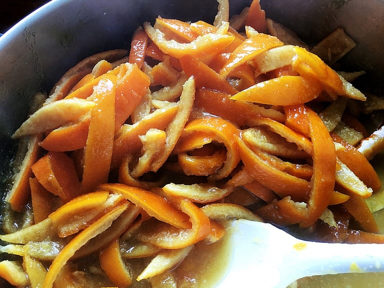 candied orange peels simmering in syrup